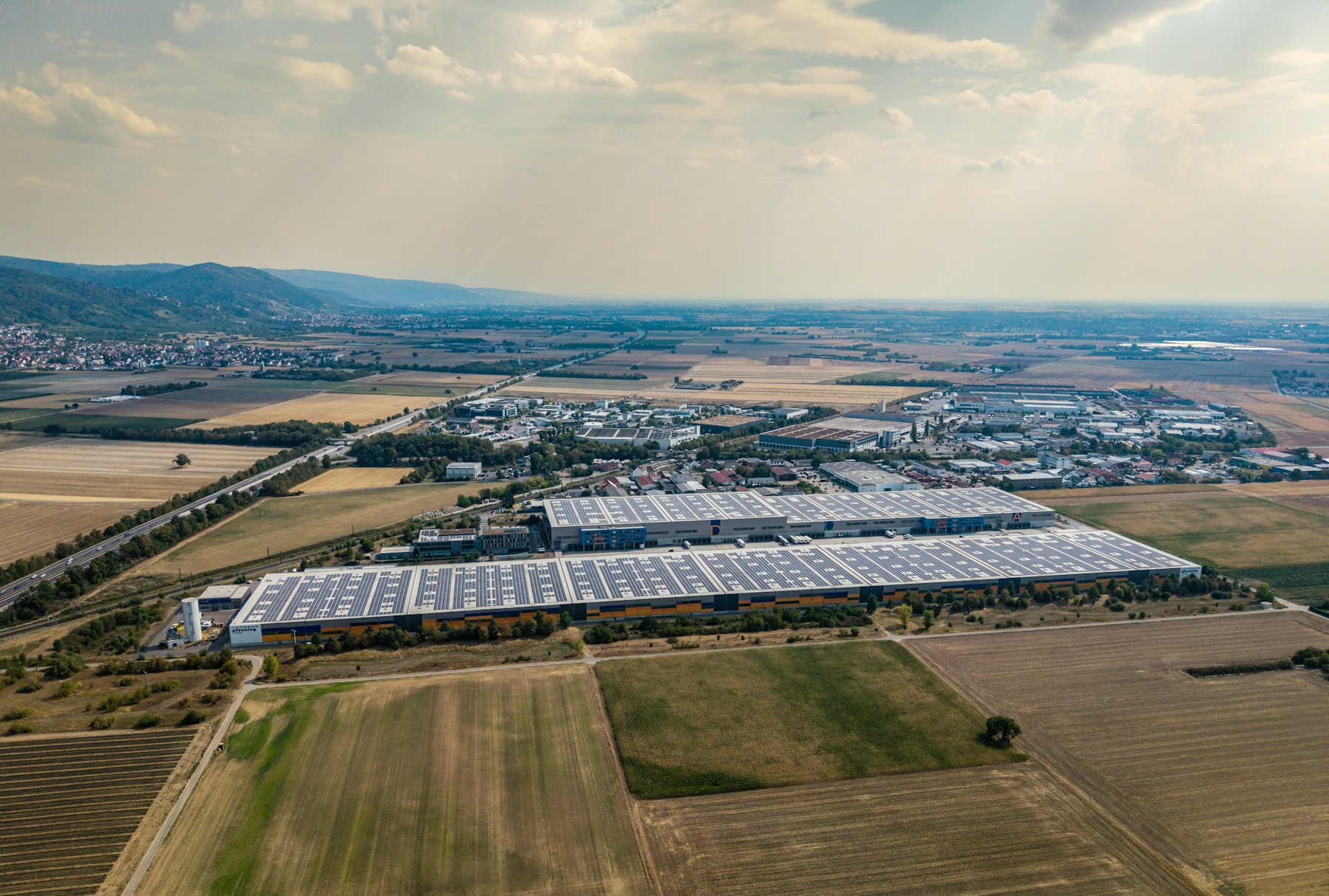 Aerial view of an industrial warehouse with rooftop solar panels